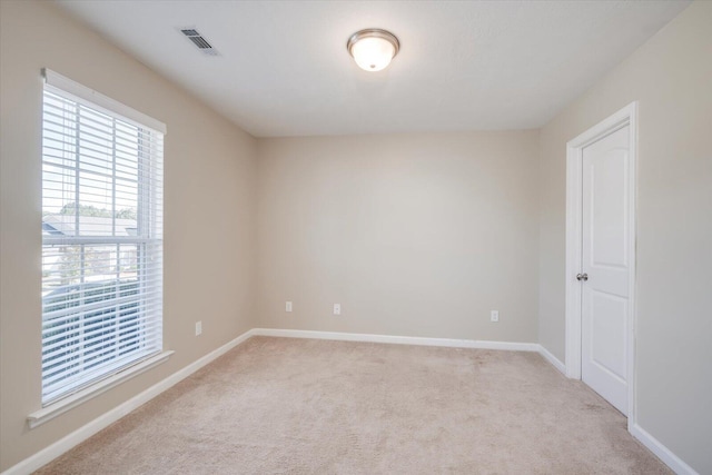 unfurnished room featuring light colored carpet