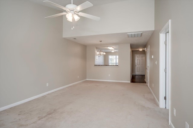 unfurnished room with ceiling fan with notable chandelier and light colored carpet