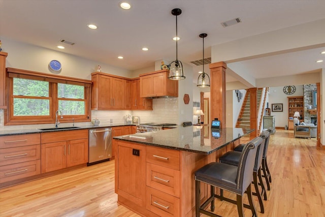 207 Rosewood Ln, Mccormick, SC 29835 - kitchen with stainless steel dishwasher, a sink, light wood-type flooring, dark stone countertops, and tasteful backsplash