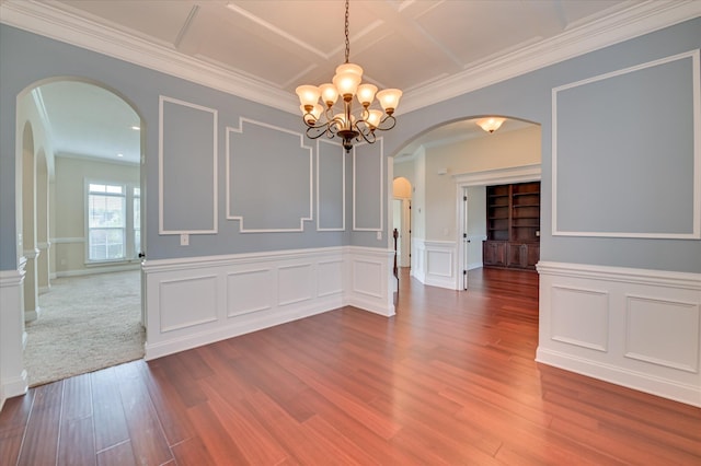 5197 Windmill Pl, Evans, GA 30809 - unfurnished dining area featuring arched walkways, a chandelier, wood finished floors, ornamental molding, and a decorative wall