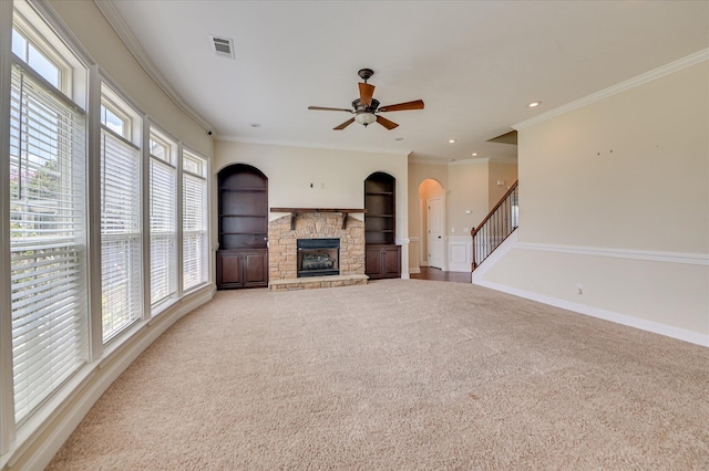 5197 Windmill Pl, Evans, GA 30809 - unfurnished living room featuring carpet, a stone fireplace, ceiling fan, ornamental molding, and arched walkways