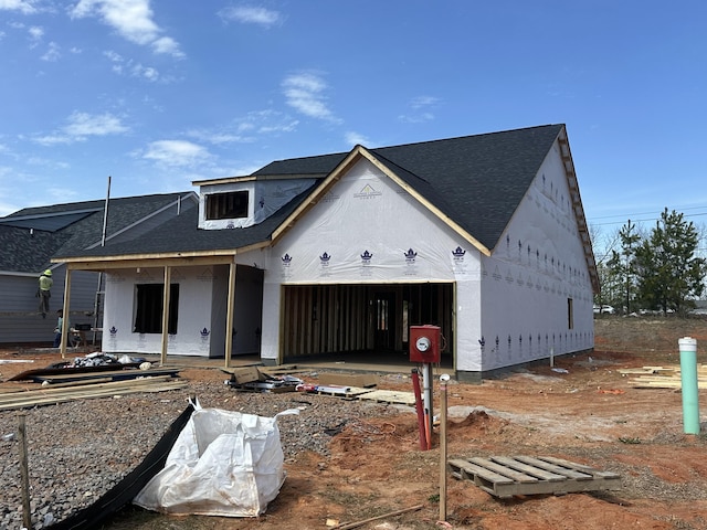 property under construction with roof with shingles, fence, an attached garage, and stucco siding