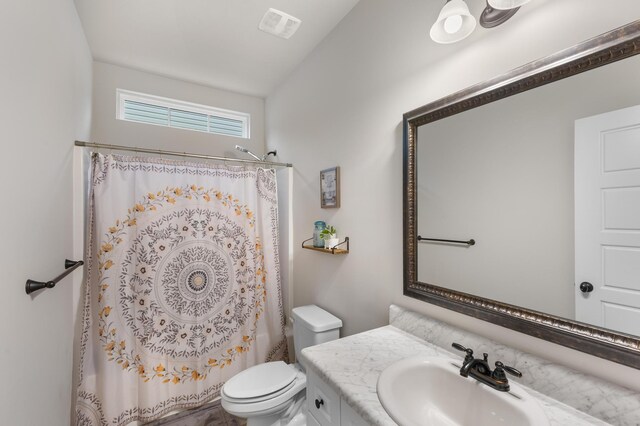 full bathroom featuring vanity, shower / bath combination with curtain, and toilet