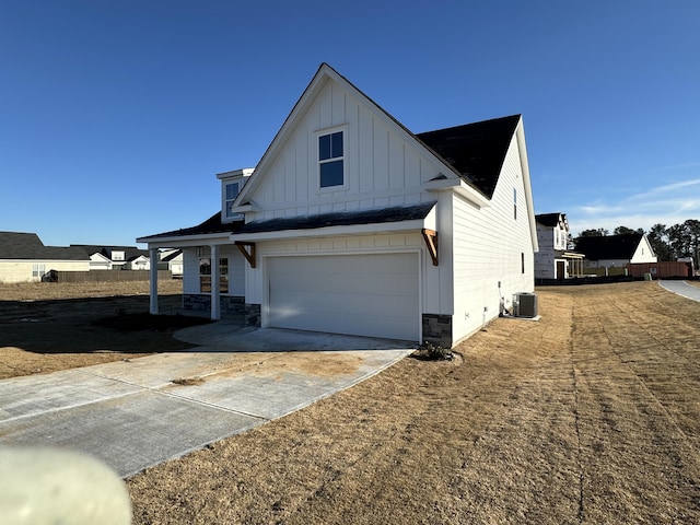 view of side of property with a garage and central AC