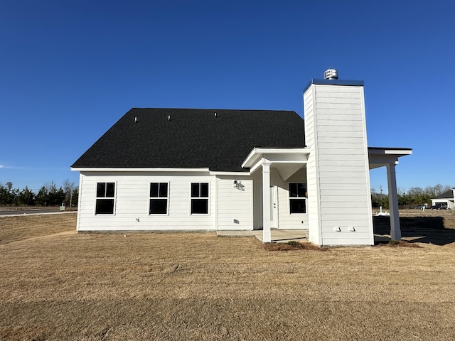 rear view of property with a patio and a lawn