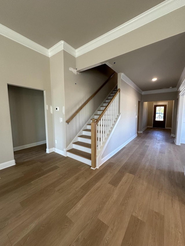 unfurnished living room featuring hardwood / wood-style flooring and ornamental molding