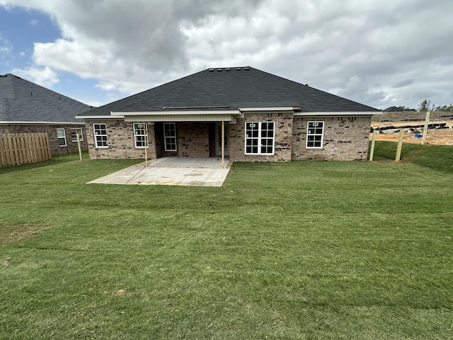back of house with a yard, fence, brick siding, and a patio