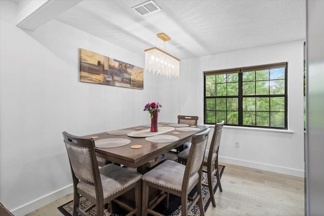 2726 Cardigan Ct, Hephzibah, GA 30815 - dining area featuring baseboards, a chandelier, light wood finished floors, and a textured ceiling