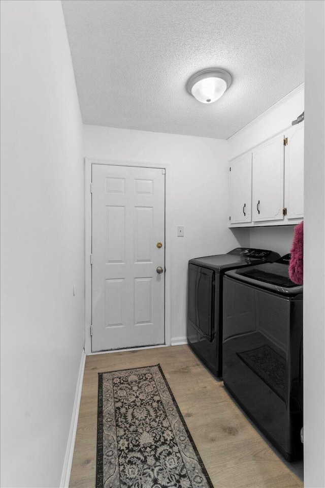 2726 Cardigan Ct, Hephzibah, GA 30815 - clothes washing area with washer and dryer, cabinet space, a textured ceiling, light wood-style floors, and baseboards