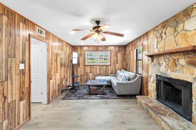 2726 Cardigan Ct, Hephzibah, GA 30815 - sitting room featuring wood walls, ceiling fan, a fireplace, and light wood-style floors