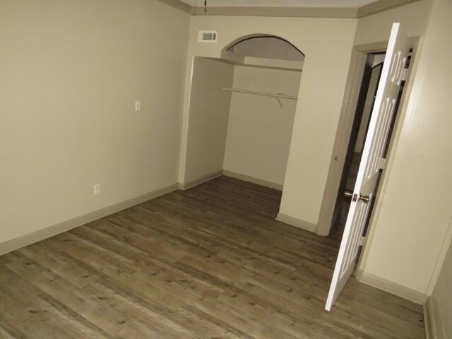 unfurnished bedroom featuring a closet and dark wood-type flooring