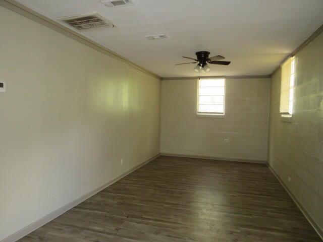 spare room with dark hardwood / wood-style floors, ceiling fan, and ornamental molding