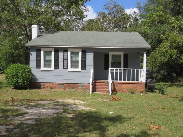 view of front facade featuring covered porch and a front yard