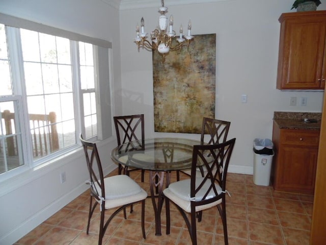 dining space with a chandelier, healthy amount of natural light, light tile patterned flooring, baseboards, and ornamental molding