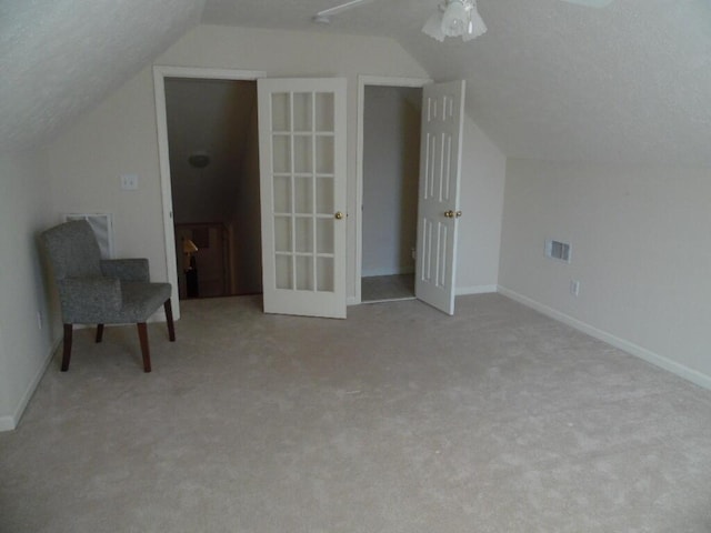 bonus room featuring vaulted ceiling and light colored carpet