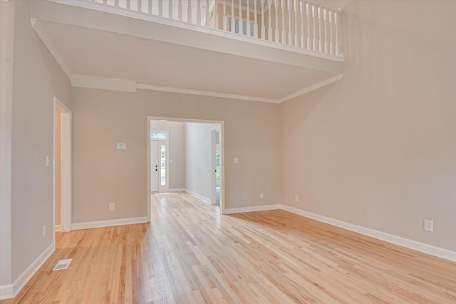 empty room with light hardwood / wood-style flooring and ornamental molding