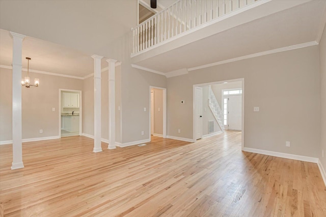 unfurnished living room featuring crown molding, a high ceiling, a notable chandelier, and light wood-type flooring