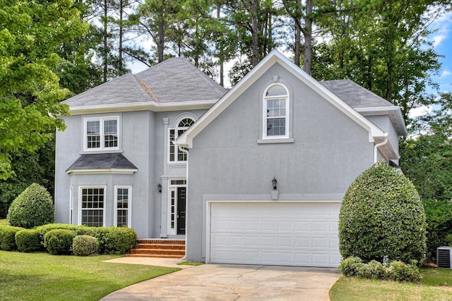 front of property with central AC unit, a front yard, and a garage