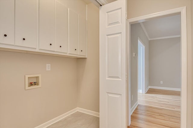 clothes washing area with cabinets, ornamental molding, and hookup for a washing machine