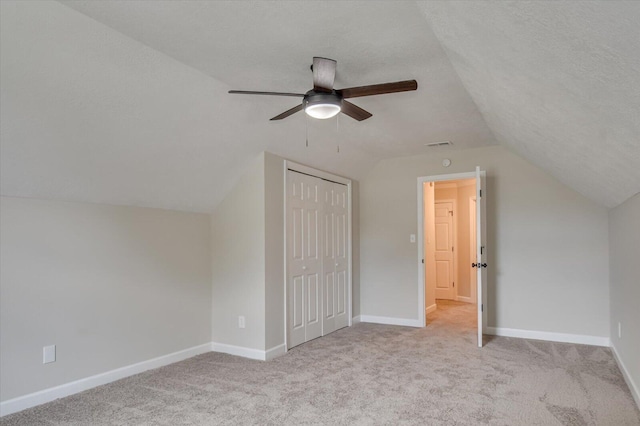 additional living space featuring light carpet, a textured ceiling, ceiling fan, and lofted ceiling