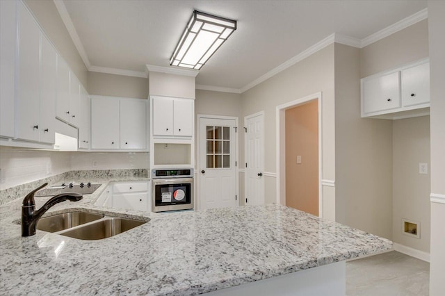 kitchen featuring oven, white cabinetry, sink, and ornamental molding