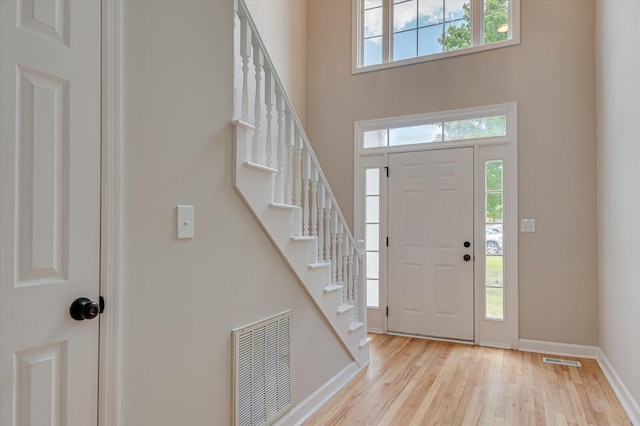 foyer with light hardwood / wood-style flooring and a high ceiling