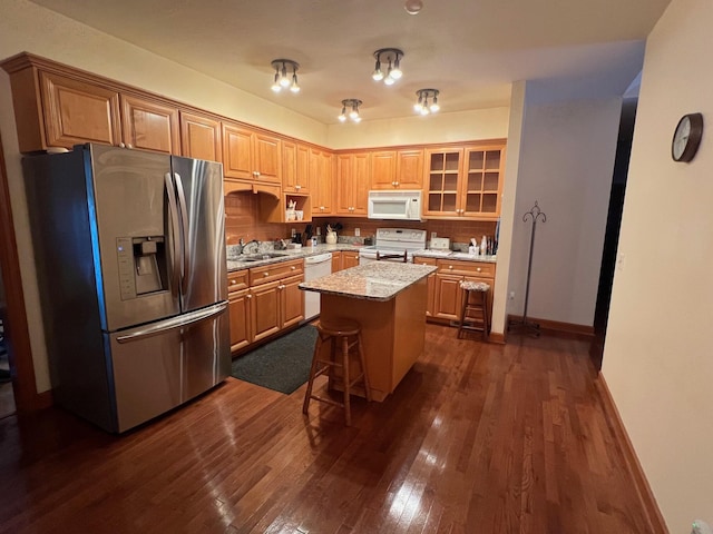 139 Cresent Dr, Mccormick, SC 29835 - kitchen with white appliances, dark wood-type flooring, a center island, a kitchen bar, and glass insert cabinets