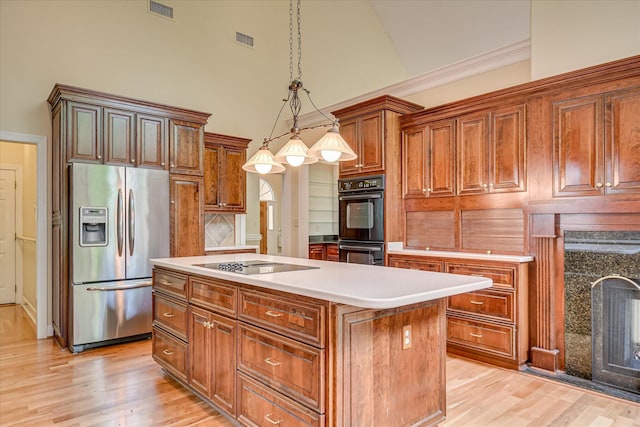 12 Shadowbrook Cir, Augusta, GA 30909 - kitchen with black appliances, a center island, high vaulted ceiling, light wood-type flooring, and brown cabinets