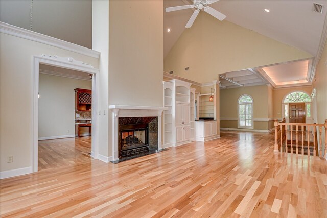 12 Shadowbrook Cir, Augusta, GA 30909 - unfurnished living room featuring a high end fireplace, a towering ceiling, light wood-type flooring, a ceiling fan, and baseboards