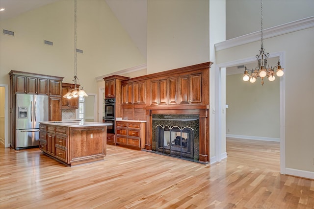 12 Shadowbrook Cir, Augusta, GA 30909 - kitchen featuring stainless steel fridge, a chandelier, high vaulted ceiling, a multi sided fireplace, and baseboards