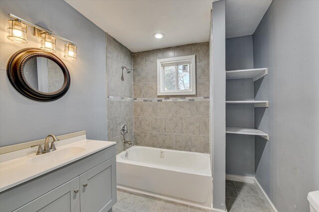 bathroom with shower / bathing tub combination, tile patterned floors, baseboards, and vanity