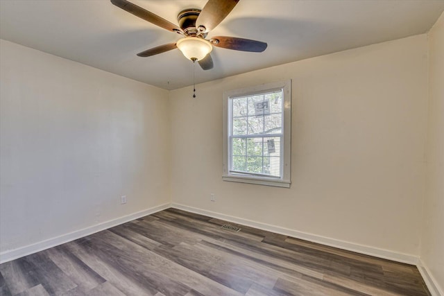 unfurnished room with baseboards, a ceiling fan, dark wood-type flooring, and visible vents