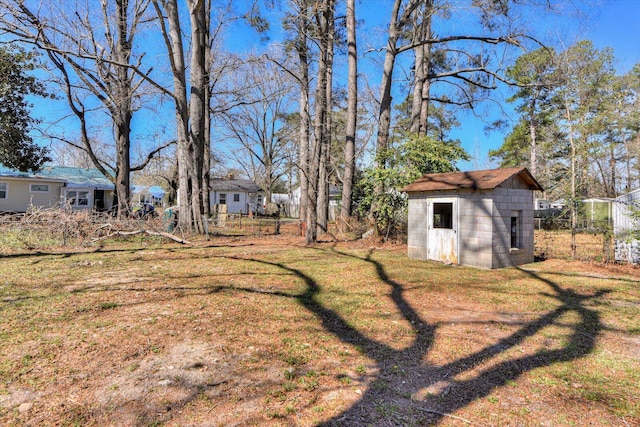 view of yard with an outdoor structure, fence, and a shed