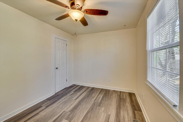 unfurnished room featuring wood finished floors, baseboards, and ceiling fan