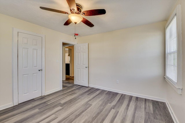 unfurnished bedroom with baseboards, a ceiling fan, and wood finished floors