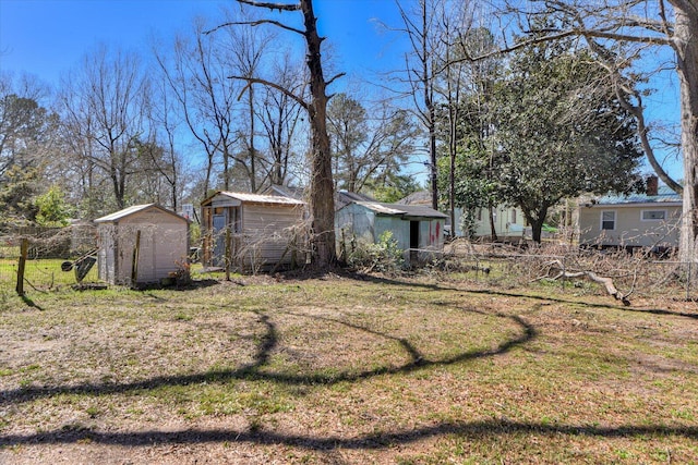 view of yard featuring fence, an outbuilding, and a storage shed