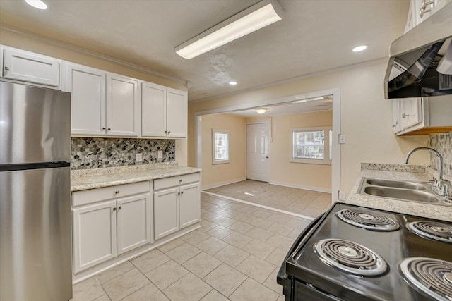 kitchen featuring a sink, tasteful backsplash, electric range, freestanding refrigerator, and light tile patterned floors