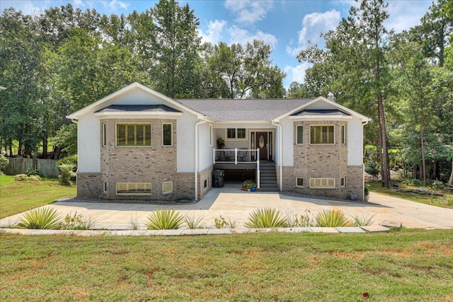 view of front facade featuring a front lawn, stairs, brick siding, and a porch