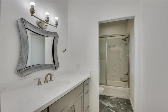full bathroom featuring marble finish floors, toilet, vanity, baseboards, and combined bath / shower with glass door