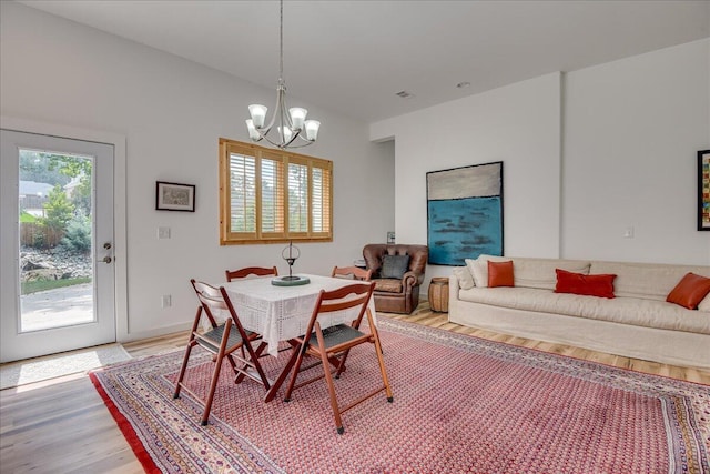 dining room with light wood-style floors and a chandelier