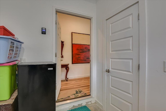 hallway with baseboards and wood finished floors