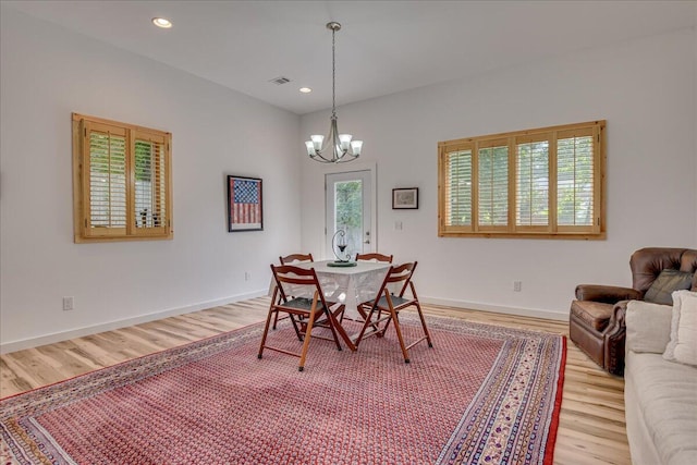 dining room featuring light wood-style floors, a chandelier, baseboards, and recessed lighting