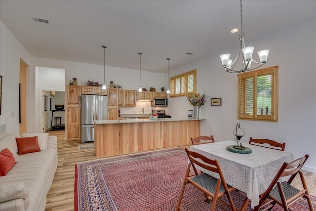 dining room featuring light wood-style flooring and a chandelier