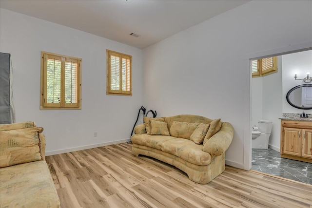 living area with light wood-style flooring and baseboards