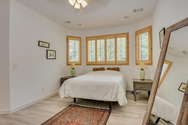 bedroom with multiple windows, light wood finished floors, baseboards, and recessed lighting