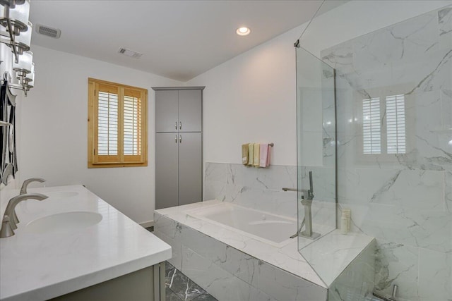 bathroom with a garden tub, double vanity, recessed lighting, a marble finish shower, and marble finish flooring