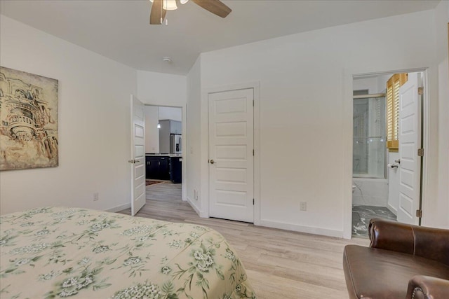 bedroom with light wood-style floors, ensuite bathroom, baseboards, and ceiling fan