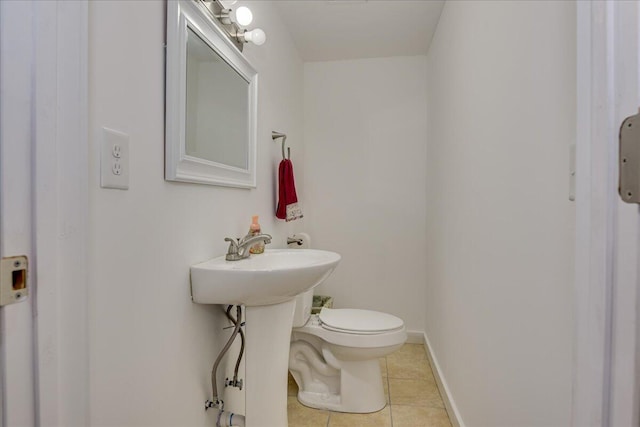 bathroom featuring tile patterned flooring, toilet, and baseboards