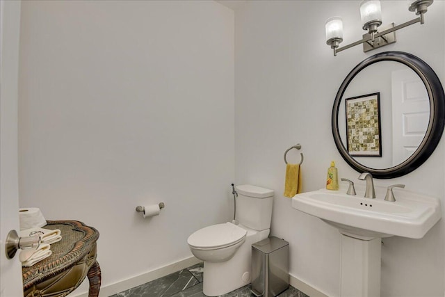 bathroom featuring baseboards and toilet