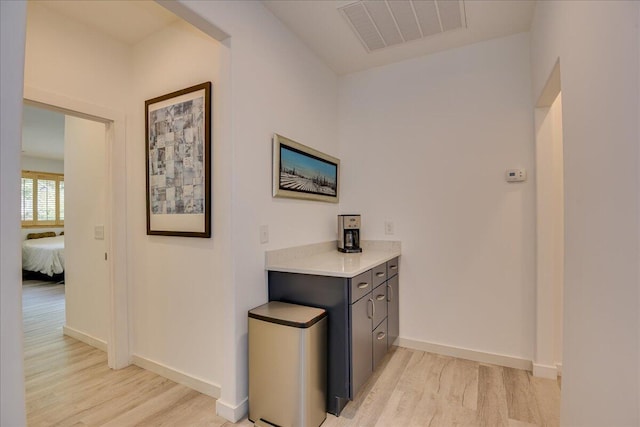 corridor with light wood-style flooring and baseboards